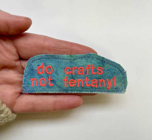 a hand holding a piece of cloth with words on it
