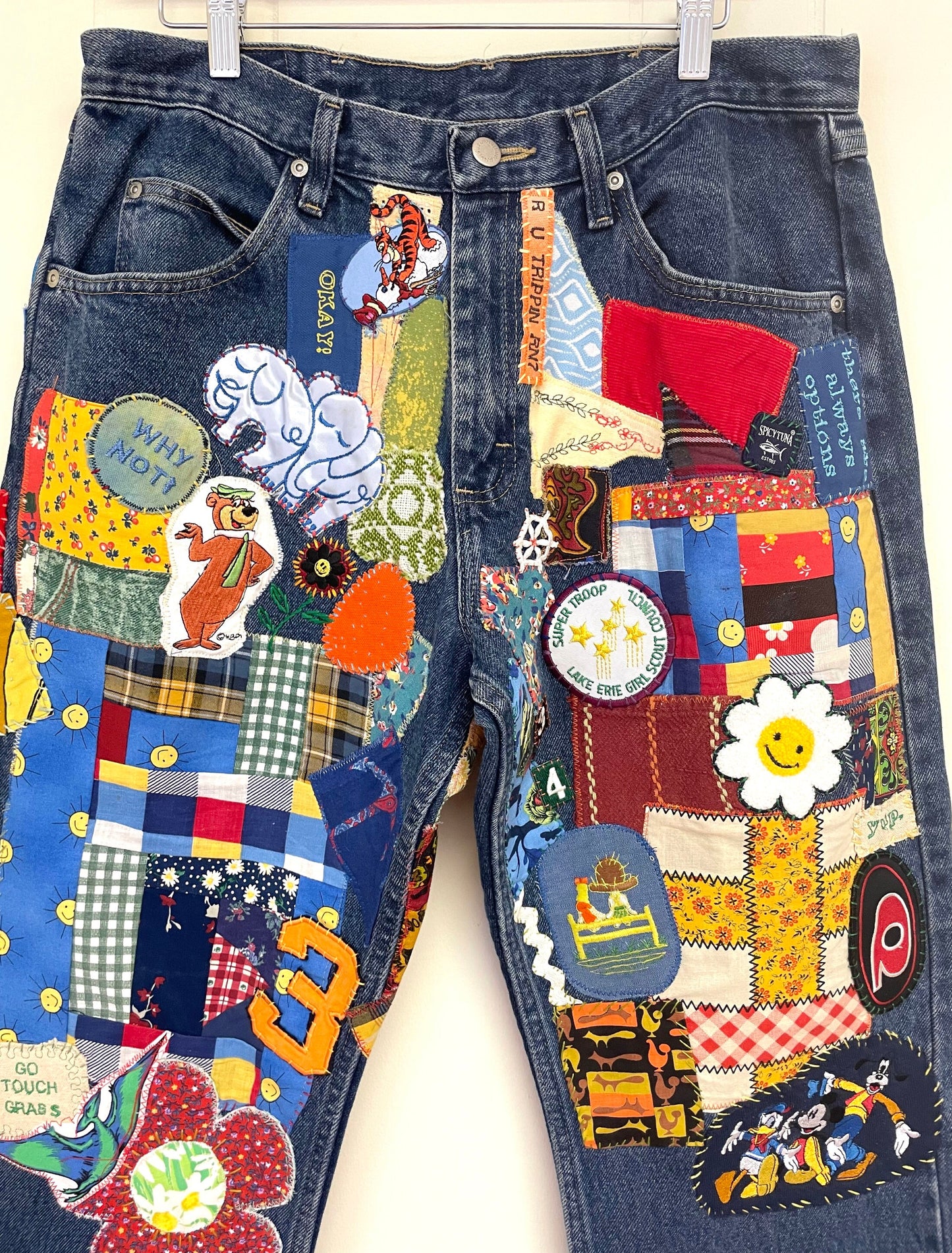 a pair of jeans with patches and buttons on them