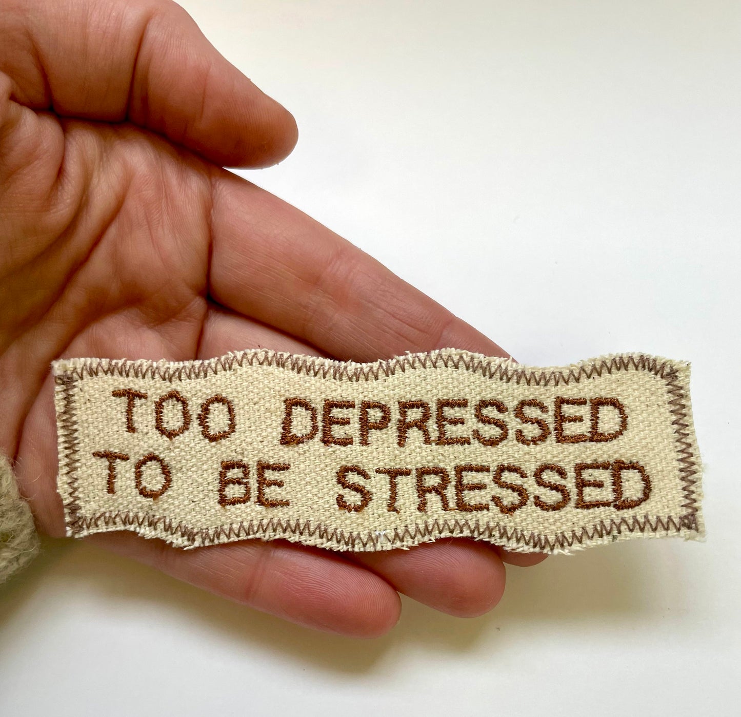 a hand holding a piece of cloth with a message on it