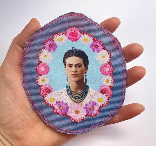 a hand holding a picture of a woman with flowers