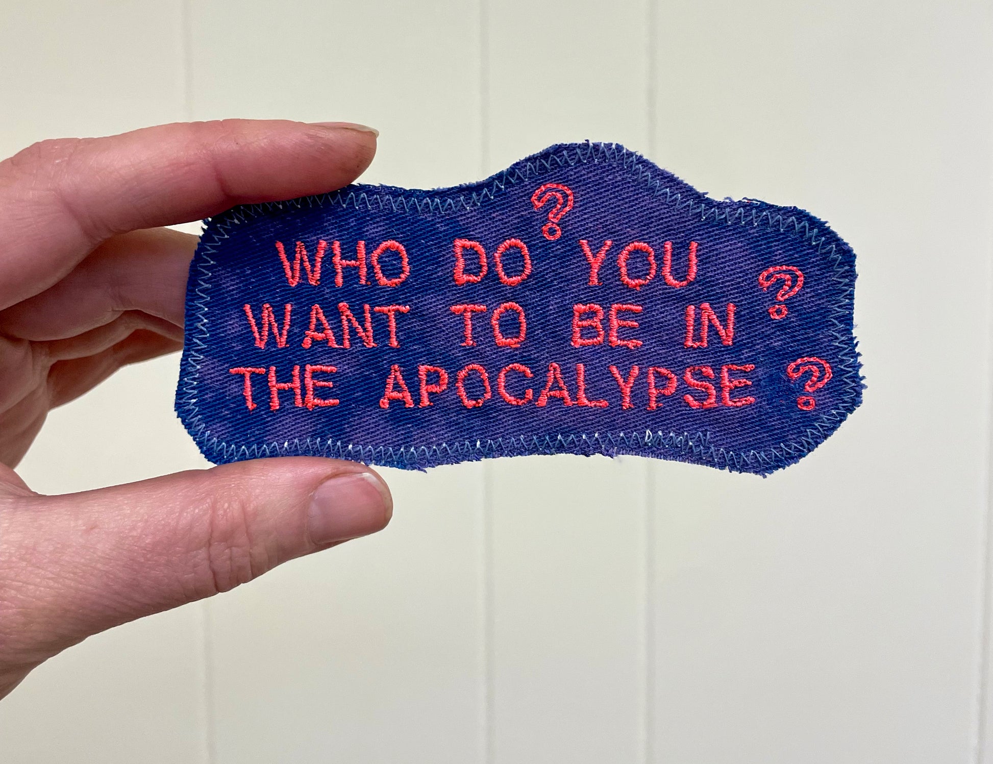 a hand holding a patch that says who do you want to be in the ap
