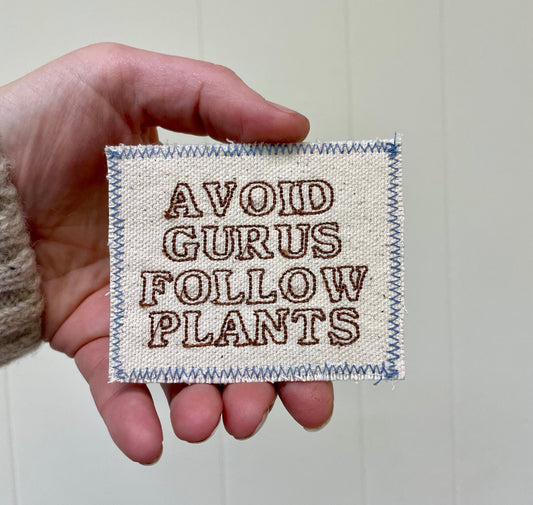 a person holding a small patch with words on it