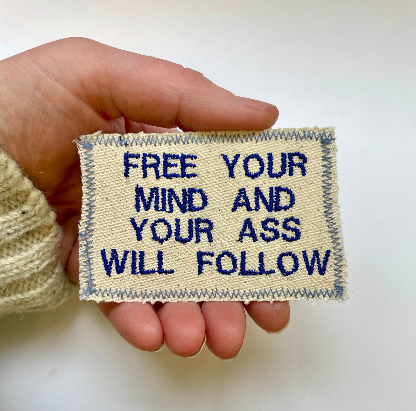 a hand holding a piece of cloth that says free your mind and your ass will