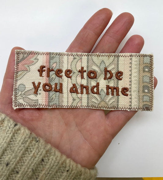 a hand holding a piece of fabric with a message on it