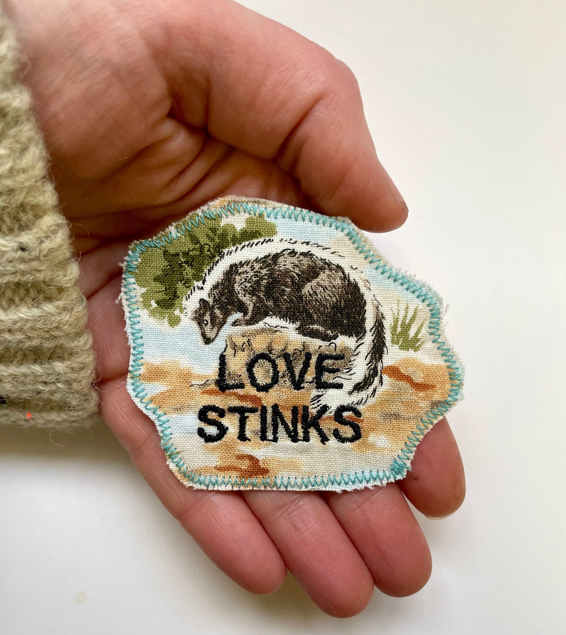a hand holding a patch with a picture of a bear on it