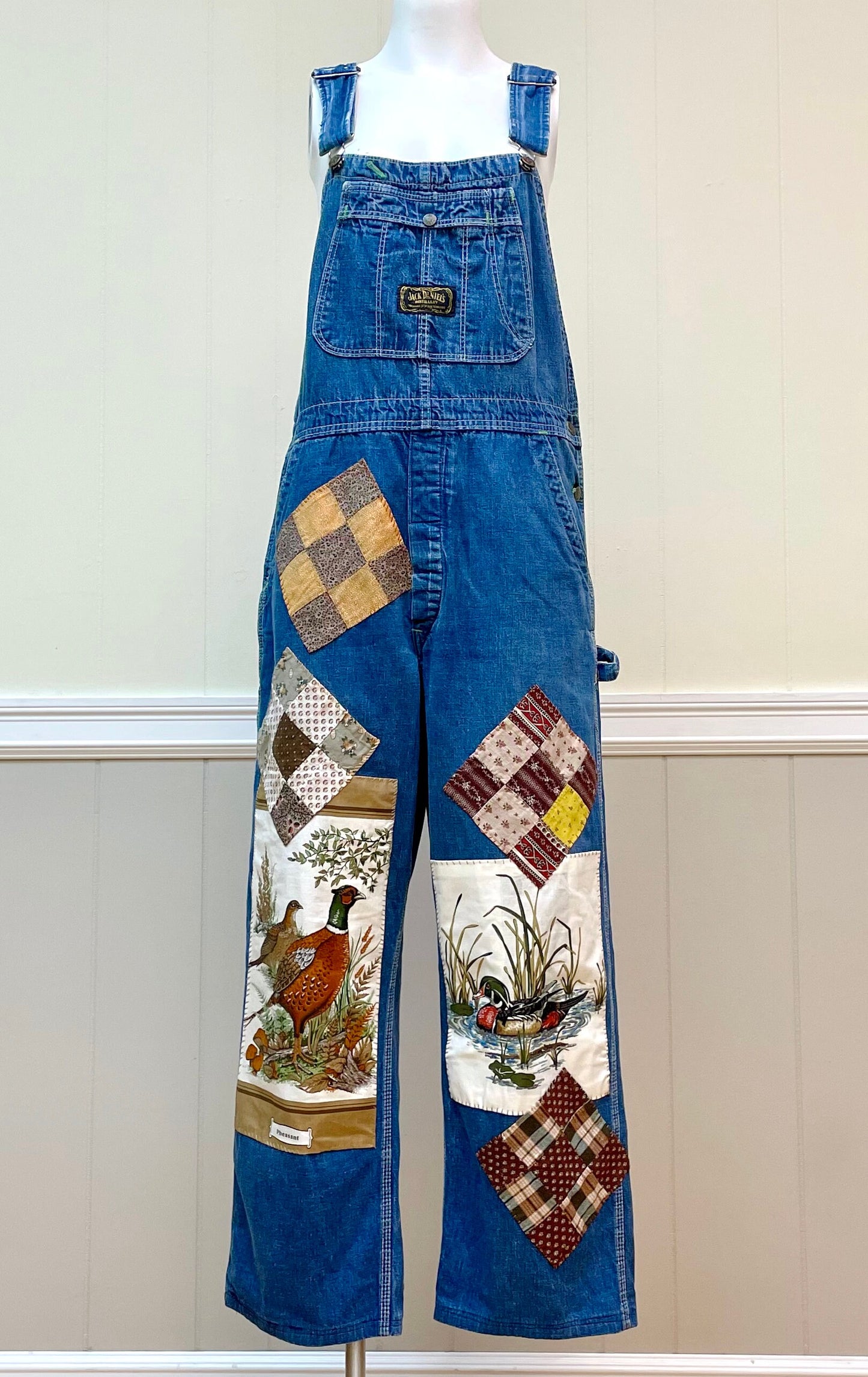 a mannequin wearing overalls with patches on them