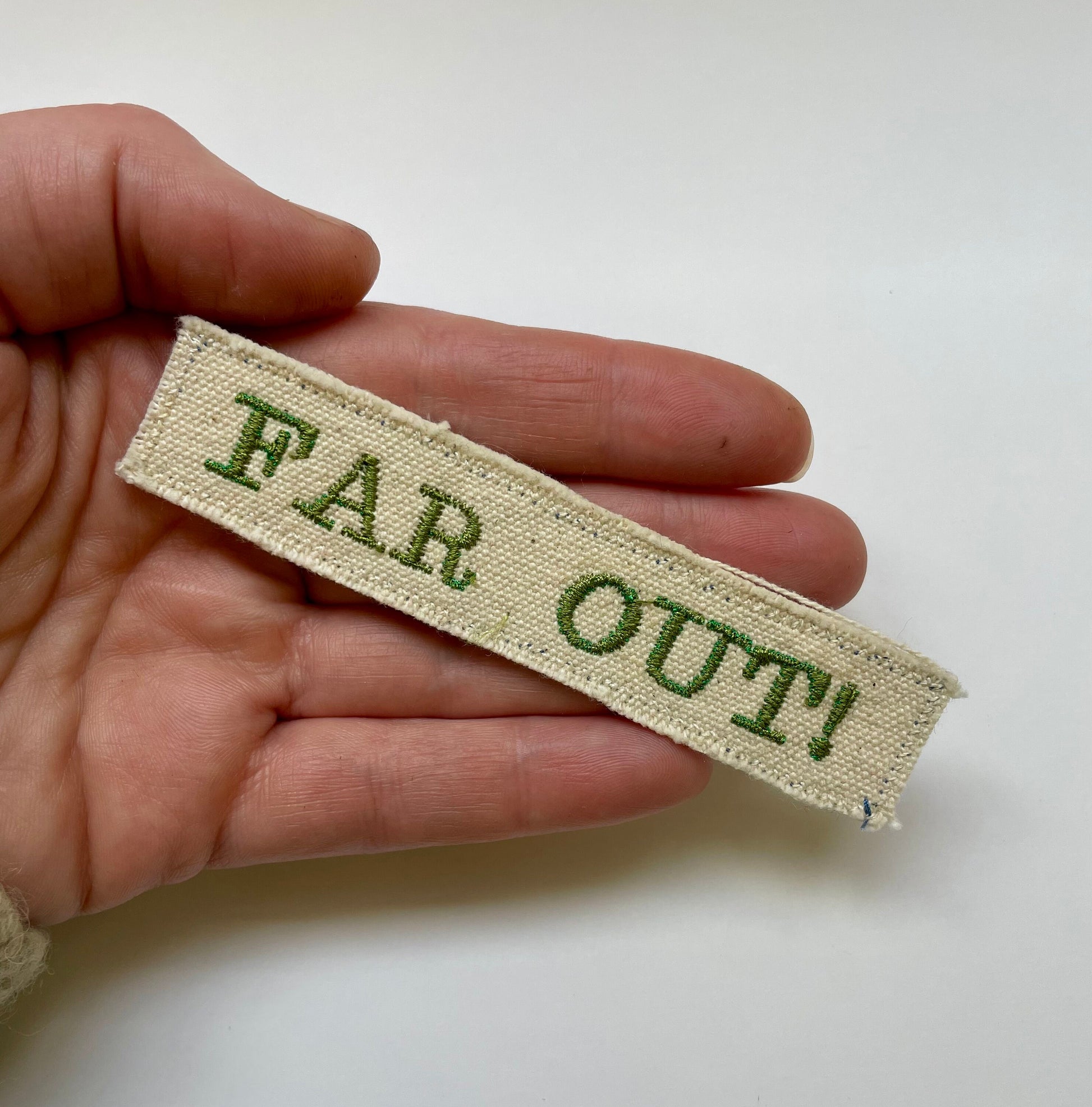 a person is holding a tag that says far out
